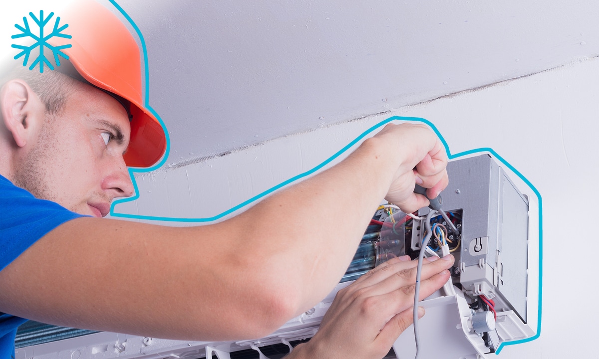 Technik zapája klimatizáciu do elektrickej sústavy.