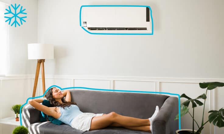 Žena v obývačke, ktorá leží na pohovke a ochladzuje sa klímou