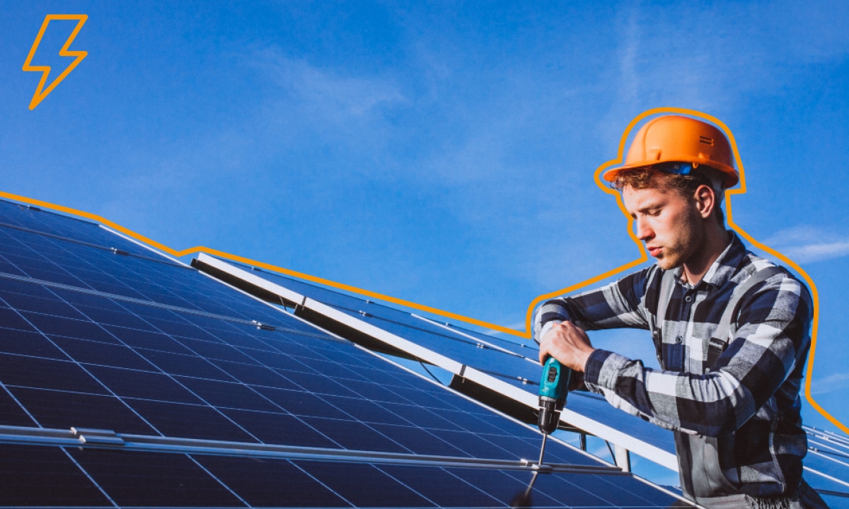 Muž na streche zapájajúci fotovoltaický panel