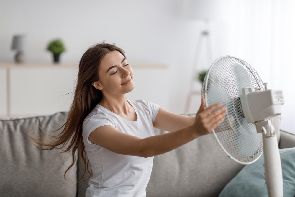 Slečna pred ventilátorom v teplej izbe